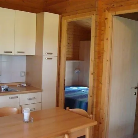 Holzchalet Mit Ueberdachter Veranda Und Terrassenmoebeln Auf Einem Schoenen Campingplatz Casa vacanze *